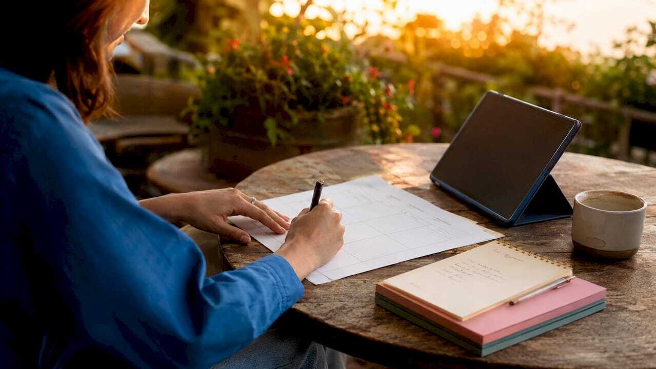 Hands completing a digital marketing plan template